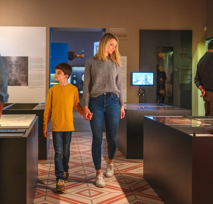 A woman and child walking through a museum exhibit